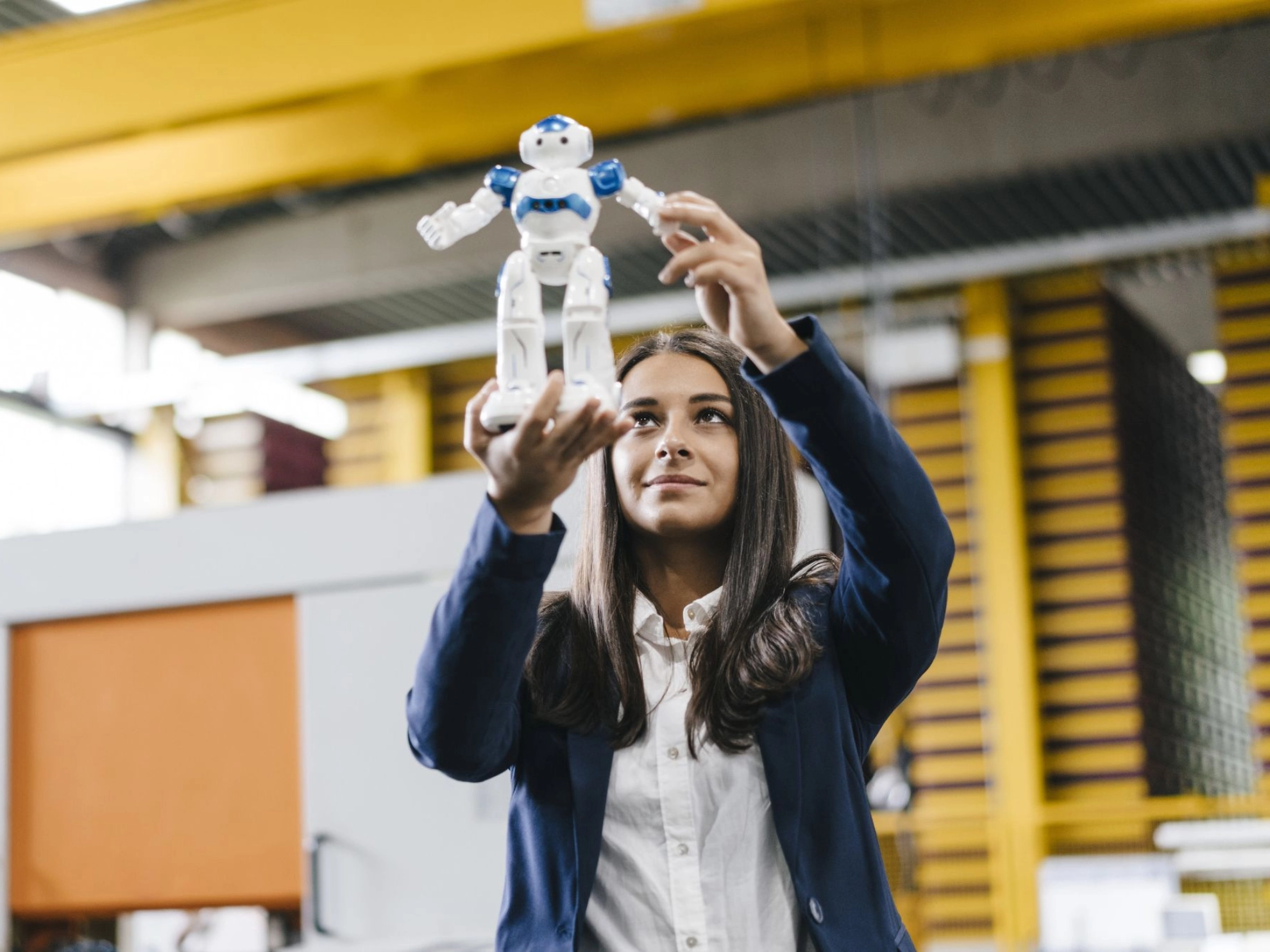 Junge Frau hält Mini-Roboter vor sich